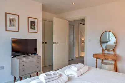 a bedroom with a bed and a mirror and a television at Finest Retreats - Tamsin in Newquay