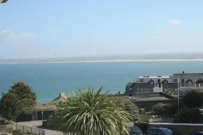 a view of the ocean with houses and a palm tree at Rivendell Guest House in St Ives