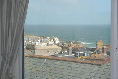 a view from a window of a town and the ocean at Rivendell Guest House in St Ives
