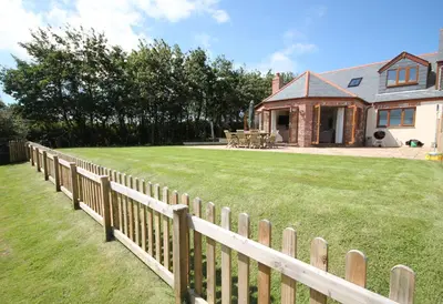 a wooden fence in front of a house at Rocksalt in Saint Minver