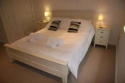 a bedroom with a white bed with towels on it at Rocksalt in Saint Minver