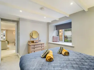 a bedroom with a blue bed with two pillows at Sun Trap Terrace in Porthleven