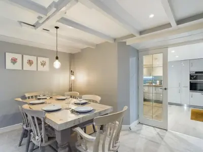 a dining room with a table and chairs at Sun Trap Terrace in Porthleven