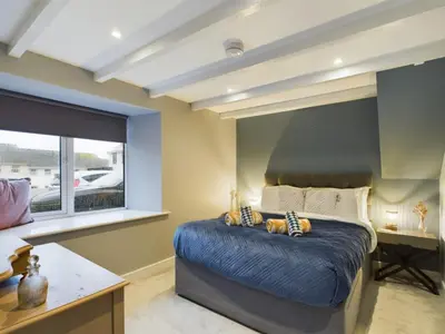 a bedroom with a large bed and a window at Sun Trap Terrace in Porthleven