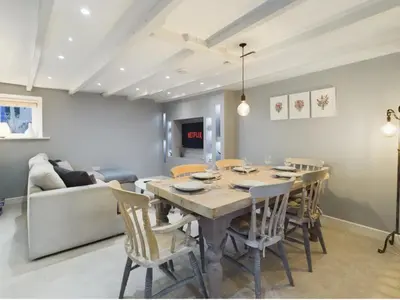 a dining room with a table and chairs and a couch at Sun Trap Terrace in Porthleven