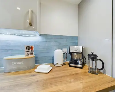 a kitchen counter with several appliances on a wooden counter top at Sun Trap Terrace in Porthleven