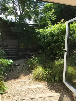 a garden with a stone path and grass at Peaceful Scandi Garden room in Falmouth