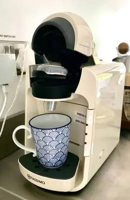 a coffee maker with a cup on top of it at Peaceful Scandi Garden room in Falmouth
