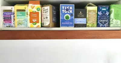 a shelf with different types of food items on it at Peaceful Scandi Garden room in Falmouth