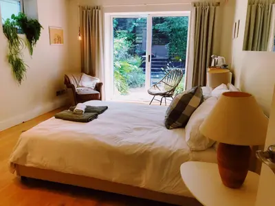 a bedroom with a large bed with a window at Peaceful Scandi Garden room in Falmouth