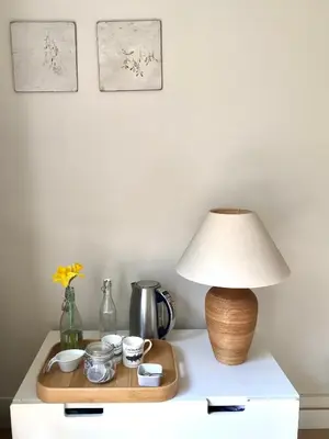 a table with a lamp and a tray on it at Peaceful Scandi Garden room in Falmouth