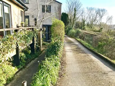 a dirt road in front of a house at Peaceful Scandi Garden room in Falmouth