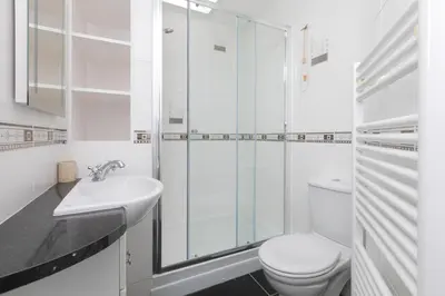 a white bathroom with a toilet and a sink at Coastal Breeze in Carbis Bay