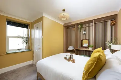 a bedroom with a white bed and a mirror at The Secret Seascape - Free Parking - Free WiFi - Carbis Bay in Carbis Bay