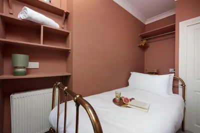 a bedroom with a bed with a book shelf at The Secret Seascape - Free Parking - Free WiFi - Carbis Bay in Carbis Bay