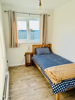 a bedroom with a bed and two windows at The White House in St Merryn