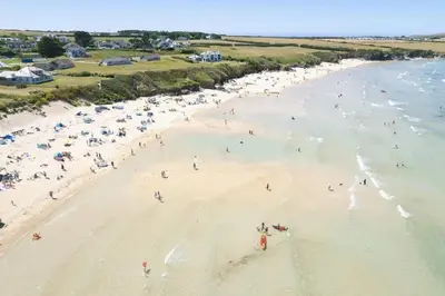 an overhead view of a beach with people in the water at The White House in St Merryn