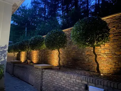 a brick wall with a row of trees on it at Hunters Moon in St Austell