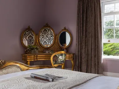 a bedroom with a bed with mirrors on the wall at Hunters Moon in St Austell