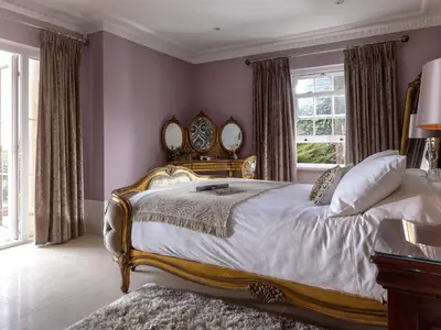 a bedroom with a large bed with two mirrors at Hunters Moon in St Austell