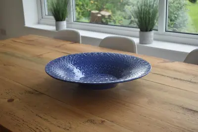 a blue bowl sitting on top of a wooden table at Coastal house, large garden, 4 bedrooms, 2 bathrooms, BBQ, 10 min walk to beach in Mawnan Smith