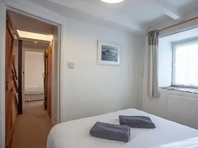a bedroom with a bed with two towels on it at Hayloft - Uk48766 in Looe