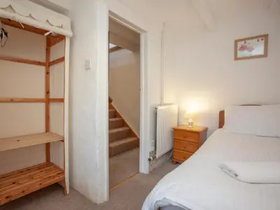a bedroom with a bed and a stair case at Hayloft - Uk48766 in Looe