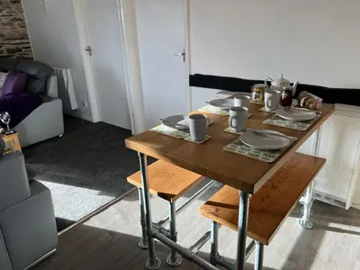 a wooden table with dishes on it in a living room at Hop Loft-Barn Conversion, with access to Pool & Hot Tub-at Fox Valley Cottages in Looe