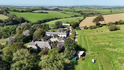 an aerial view of a house in a green field at Hop Loft-Barn Conversion, with access to Pool & Hot Tub-at Fox Valley Cottages in Looe