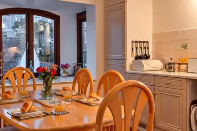 a kitchen with a wooden table with bread on it at Finest Retreats - Tregenna Court in Falmouth