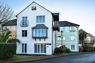 a white house with black windows and a street at Finest Retreats - Tregenna Court in Falmouth
