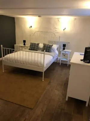 a bedroom with a white bed and a table and a desk at The Engine Inn in Penzance