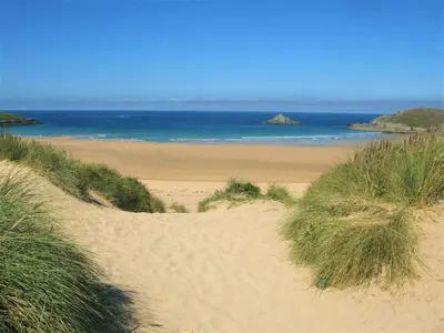 a sandy beach with the ocean in the background at Cottage in Crantock, seaviews, 10min walk to beach in Crantock