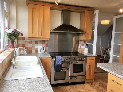 a kitchen with a stove and a sink in it at Cottage in Crantock, seaviews, 10min walk to beach in Crantock