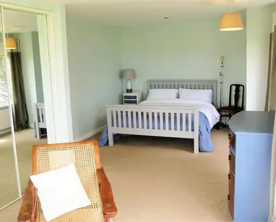 a bedroom with a bed and a chair in it at Cottage in Crantock, seaviews, 10min walk to beach in Crantock