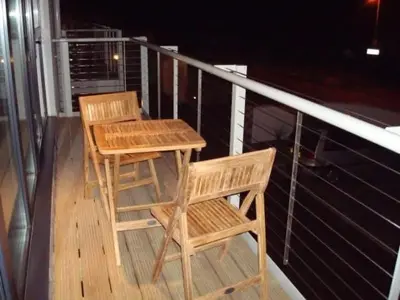 two wooden chairs and a table on a balcony at Fistral View Apartment in Newquay