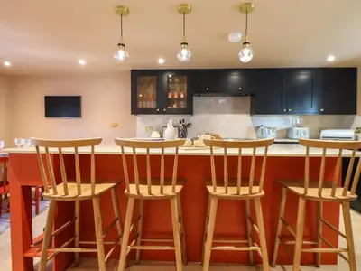 a kitchen with three bar stools in front of a counter at Mavericks Wave in St. Agnes