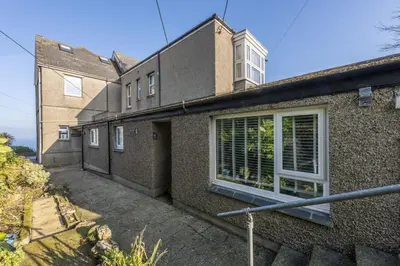 a large brick house with a window with blinds at 3 Pentowan Court, Carbis Bay in Carbis Bay