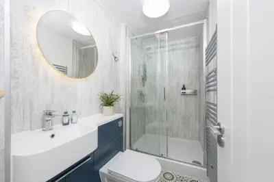 a bathroom with a shower and a toilet and a sink at 3 Pentowan Court, Carbis Bay in Carbis Bay