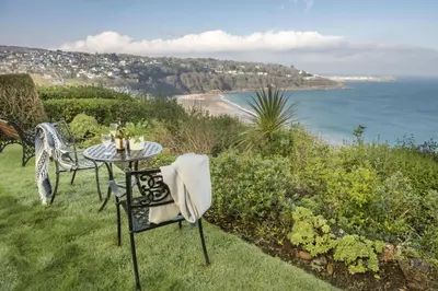 a table and chairs with a view of the ocean at 3 Pentowan Court, Carbis Bay in Carbis Bay