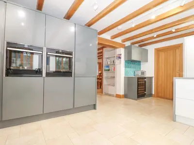 a kitchen with stainless steel appliances and a wooden ceiling at Splatt Barn in Wadebridge