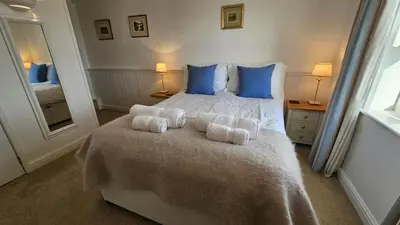a bedroom with a bed with towels on it at Pengerein in Porthscatho