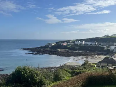 a view of a beach with houses and the ocean at Pengerein in Porthscatho