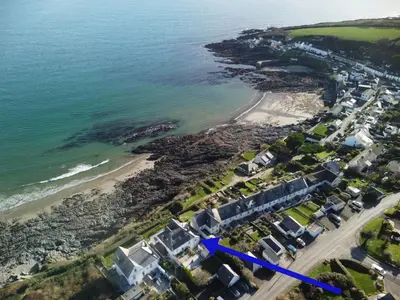 an aerial view of a beach with a blue arrow at Pengerein in Porthscatho