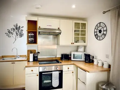 a kitchen with white cabinets and a counter top at The Studio in Bude