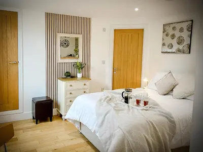 a bedroom with a bed and a table with drinks on it at The Studio in Bude