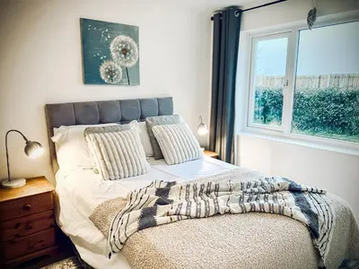 a bedroom with a large bed with a window at Trelawne in Bude