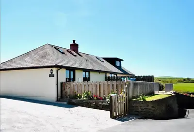 a house with a white garage and a fence at Penkenna in Bude
