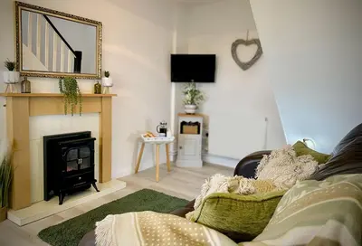 a living room with a fireplace and a couch at Penkenna in Bude