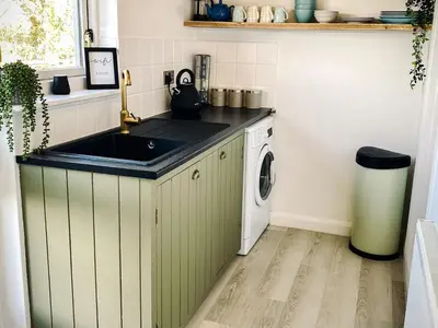 a kitchen with a sink and a washing machine at Penkenna in Bude